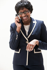 Mature African American businesswoman using cellphone, studio shot