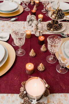 Served table with dishware and wineglasses decorated with candles