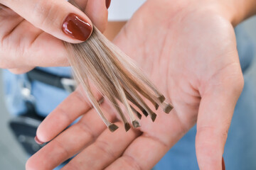 Obraz na płótnie Canvas Hair extension. Hair strands with capsules in hand.