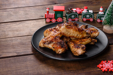 Grilled spicy chicken wings on a dark background with spices and herbs