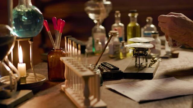 A 19th century Apothecary in his laboratory using a balance scale to measure out the amount of substance needed to formulate his medicinal potion or remedy.