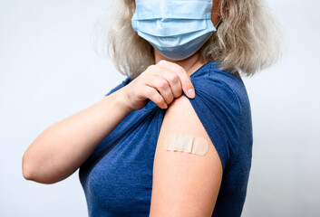Vaccinated woman showing shoulder after COVID-19 vaccine getting - obrazy, fototapety, plakaty