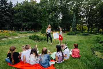 A teacher teaches a class of children in an outdoor Park. Back to school, learning during the pandemic