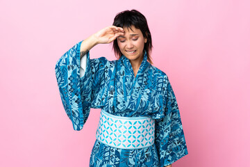 Young woman wearing kimono over isolated blue background with tired and sick expression