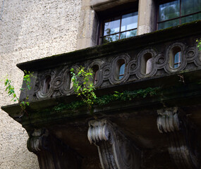 concrete balustrade of the balcony with a geometric pattern covered with moss
