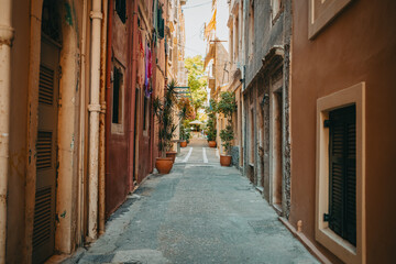 Beautiful cozy narrow street in old town of Italy or Greece. Historic european facades of buildings. Cityscape concept.