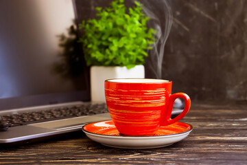 coffee cup, laptop on a wooden background, flowerpot