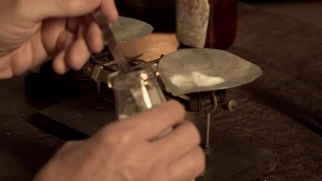 An Apothecary measuring out the amount of substance needed for his medicinal potion or remedy using a balance scale with weights.