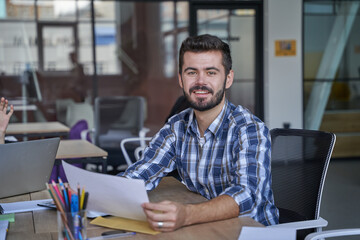 Fototapeta premium Smiling worker holding paper with financial report