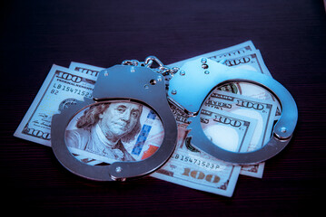 Dollars and police handcuffs. Crime.