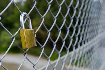 Golden padlock on chain link fence