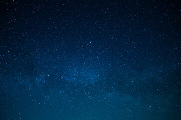 Fototapeta premium Starry night sky. Milky Way. Twinkling stars. Mysterious, majestic beauty, silence. Background. Texture. Wallpaper. Minimalism. There are no people in the photo. Astronomy, astrography, space.