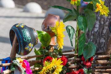 Painted clay pots and jugs on the fence.