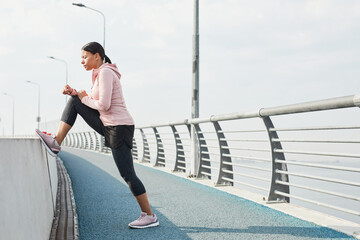 Young sportive woman doing stretching exercises on the bridge in the morning