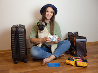 Woman collects medications in the first aid kit for pug dog. Packing for traveling with pets