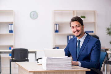 Young male employee and too much work in the office