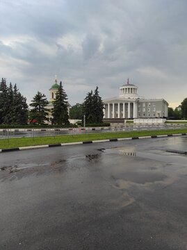 Rainy weather in Dzerzhinsk on the city day. The Palace of Culture of Chemists and the Chapel of the Archangel Michael after the rain.