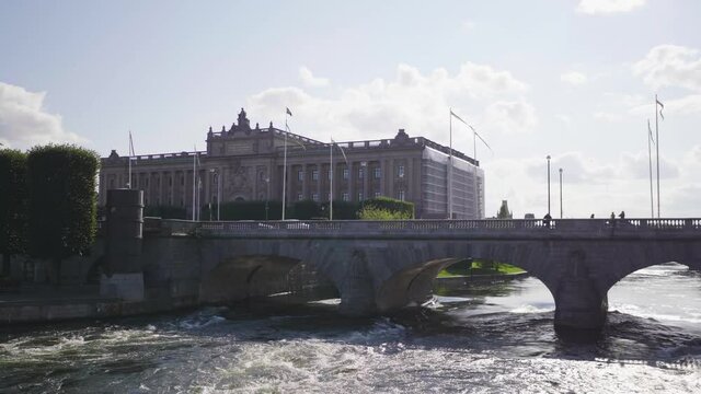 Beautiful view of river and building in Sweden, strong wave of water in the river flow through below the bridge. View of the bridge over the river with blue sky.