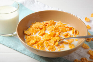  Crispy cornflakes with milk for breakfast on the table close-up.