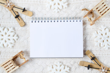 winter flat lay with snowflakes, notebook, sleds and skis