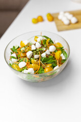 Woman Making raw green salad with cherries