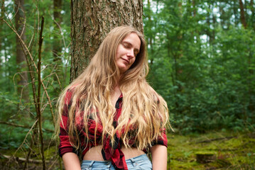An attractive Caucasian female in the forest with blond long hair