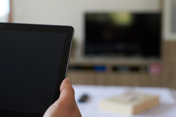 Woman turning on a tablet relaxed on the sofa