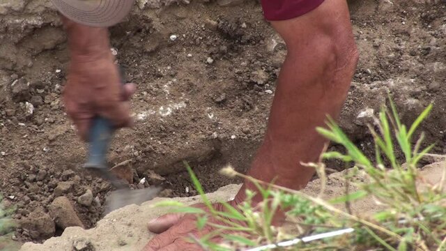 Archaeological excavations, rough works on the archeological site, the archaeologist shovels the earth excavated from the walls of the ancient fortress