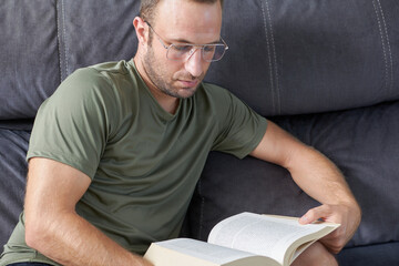 Man reading a book relaxed on the sofa