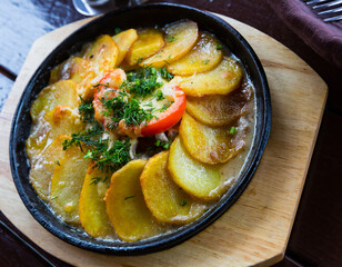 Special dish of ancient Russian cuisine Skoblyanka - potatoes and meat stewed in cream-mushroom sauce with seasonal vegetables..