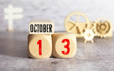 White block calendar present date 13 and month October on wood background