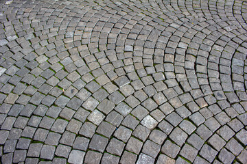 Close-up texture background view of a vintage cobblestone sidewalk surface on a European city walkway