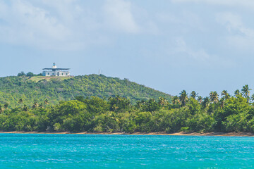 Lighthouse sits on a hill in Fajardo Puerto Rico surrounded by palm trees