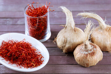 Saffron bulbs and stamens plucked from crocus on a wooden.