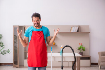 Young male contractor cleaning the house