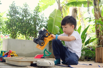 Cute Asian young kindergarten boy playing with sand alone at home, Kid playing with sand toys and...
