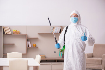 Fototapeta premium Young male contractor disinfecting at home