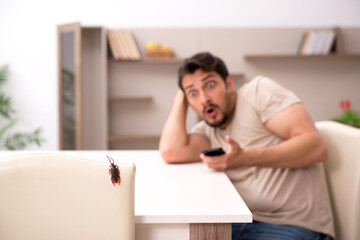 Young man and a lot of cockroaches at home