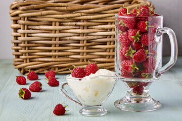 Fresh ripe raspberries and whipped cream in a glass cup