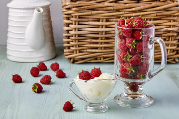 Fresh ripe raspberries and whipped cream in a glass cup