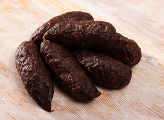 Spanish-style raw morcilla (blood sausage with rice) on wooden table..