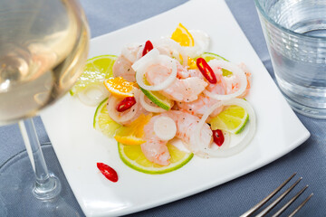 Seafood ceviche with shrimps, tangerine, lime and onion rings