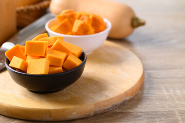 Sliced butternut squash in a bowl on wooden board preparing for cooking