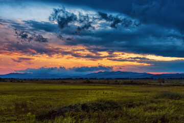 Colorful sunset over wide meadow