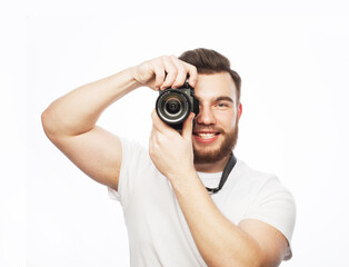 Travel, technology and life style concept: young bearded photographer taking pictures with digital camera.