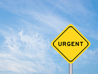 Yellow transportation sign with word urgent on blue sky background