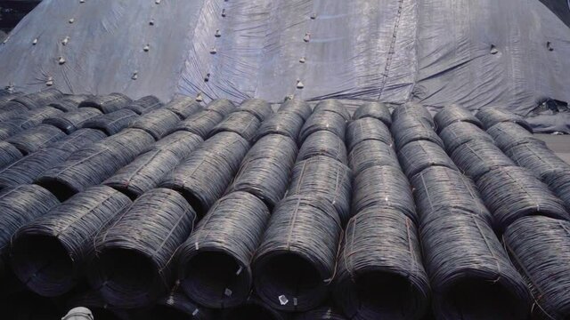 Large metal wire rolls, outdoors at the Goa Port, in sunny India - pan shot
