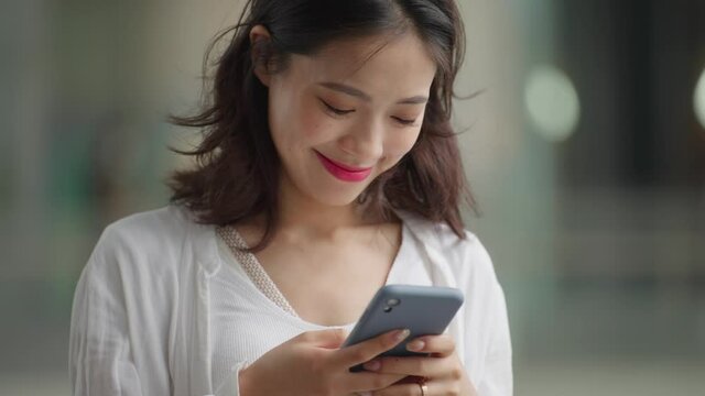 close up slow motion of pretty young asian woman looking at mobile phone in hand people using mobile phone 4k footage