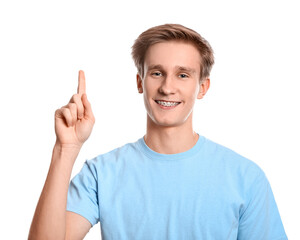 Handsome man with dental braces showing something on white background