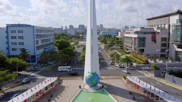 Sunny day at tall white monument with fountain and globe, Heroes Santo Domingo